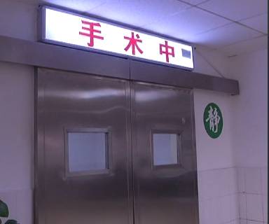 一个小伙躺在手术台上扎针,小伙在手术台上被扎针