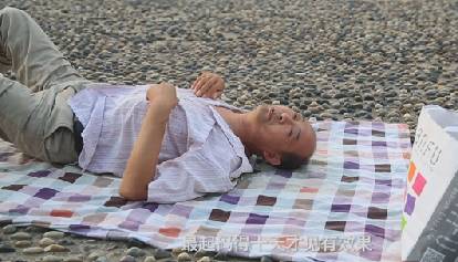 市民在鹅卵石地面做热疗,市民躺鹅卵石