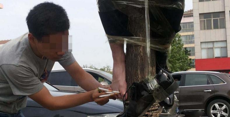 新郎被绑在电线杆上放鞭炮,新郎被绑在电杆上身挂鞭炮