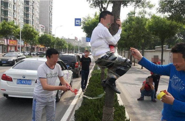 新郎被绑在电线杆上放鞭炮,新郎被绑在电杆上身挂鞭炮