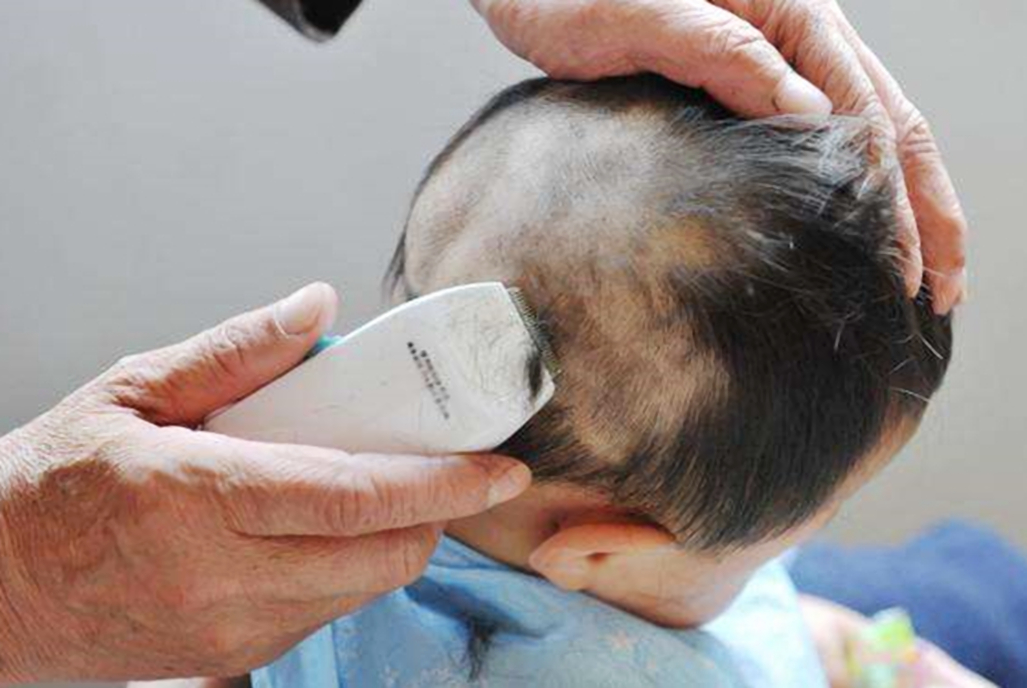 奶奶给孩子剃眉毛,给孙女剃光眉毛