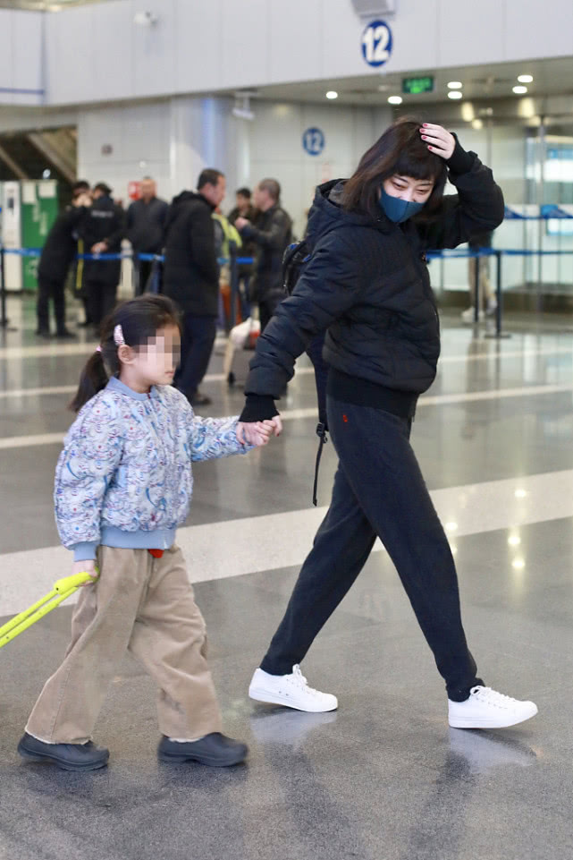 梅婷带孩子走机场,48岁梅婷黑色羽绒服配打底裤