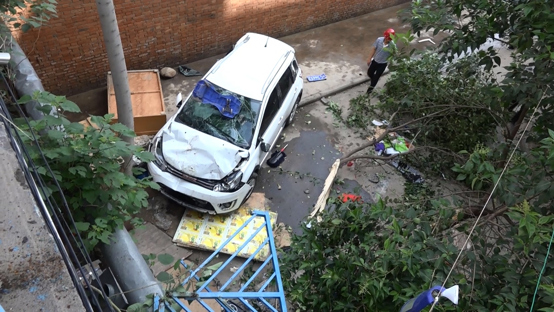 女司机油门当刹车倒着撞出数十米,一女司机错把油门当刹车