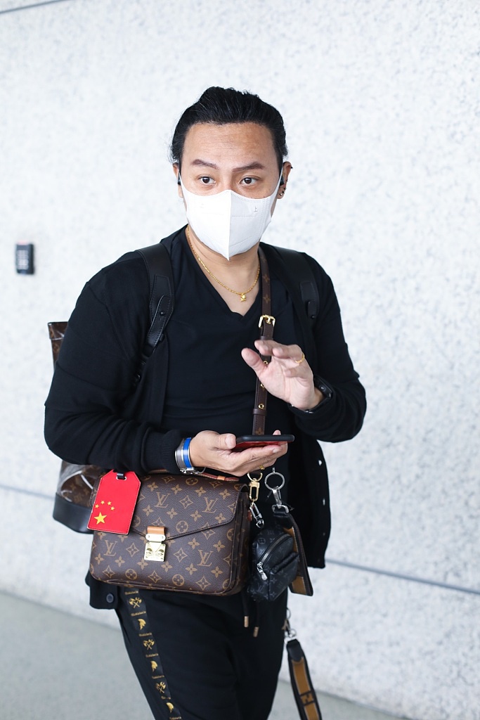 陈志朋回归低调？背3个LV包走机场，走哪都带着五星爱国手机壳