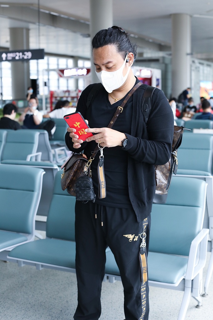 陈志朋回归低调？背3个LV包走机场，走哪都带着五星爱国手机壳