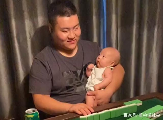 陕西一爸爸单手将宝宝抱怀里，另一只手摸牌打麻将，宝宝表情亮了