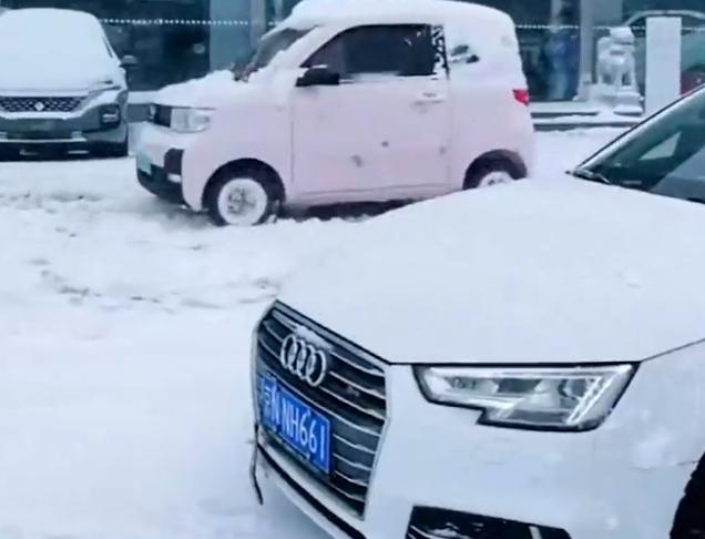 北京一奥迪因雪天打滑,车主路边卑微铲雪,“五菱萌主”轻飘划过