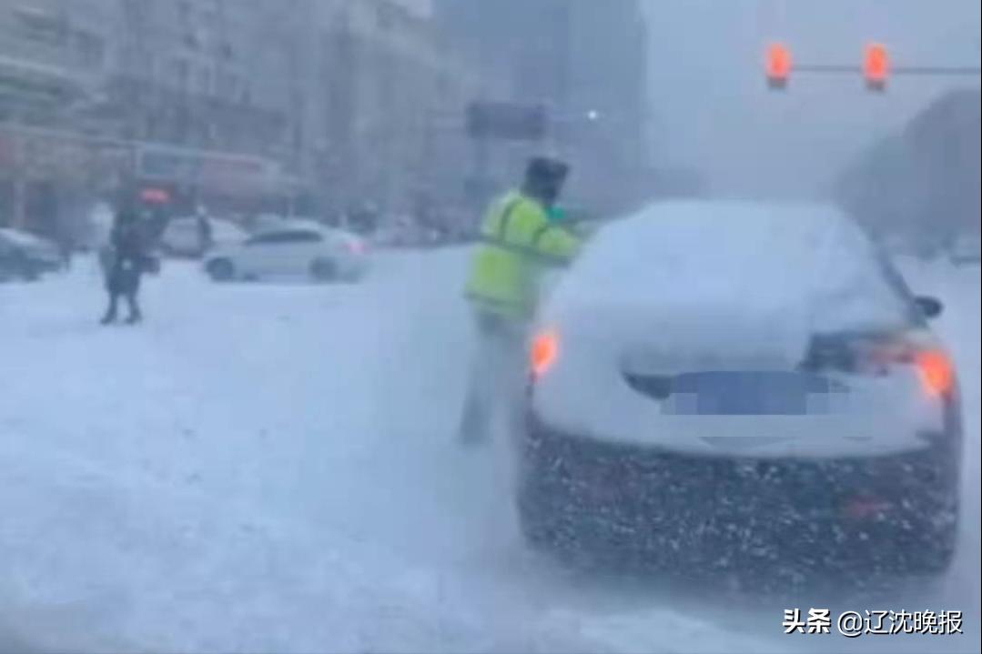 交警为等红灯车辆扫积雪,沈阳交警帮等红灯的车辆清扫积雪