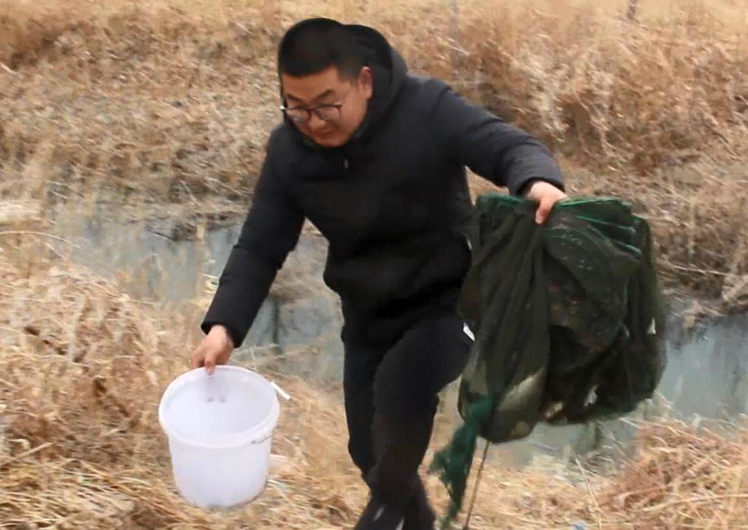 农村小伙在河里抓到一只小鱼,农村小伙河中发现废弃地笼