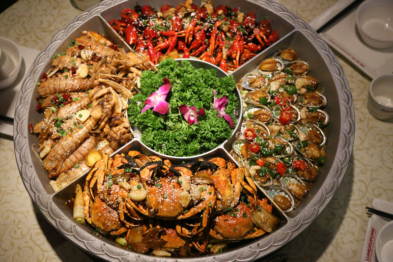 这家虾铺有搞作，在红色的海洋中剥龙虾看球，好热闹