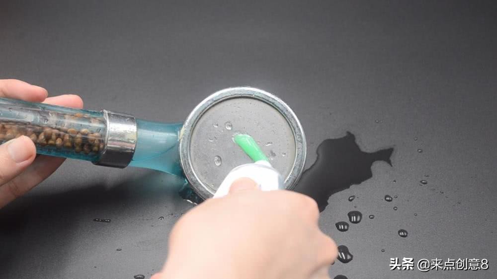 把牙膏涂抹在淋浴喷头上,把牙膏挤到喷水壶里