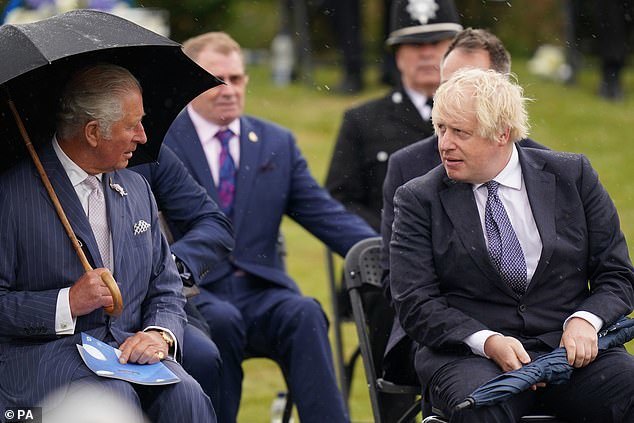 英国首相约翰逊向女士献殷勤,雨伞却是不给力,惹查尔斯王储大笑