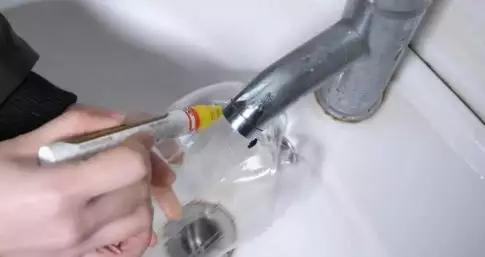 把塑料瓶套在水龙头上,塑料瓶剪下瓶盖套米袋口