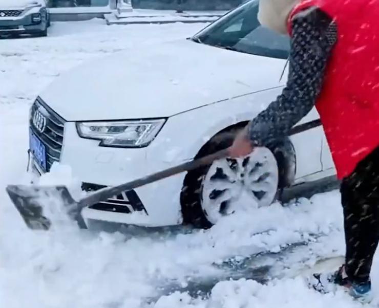 北京一奥迪因雪天打滑,车主路边卑微铲雪,“五菱萌主”轻飘划过