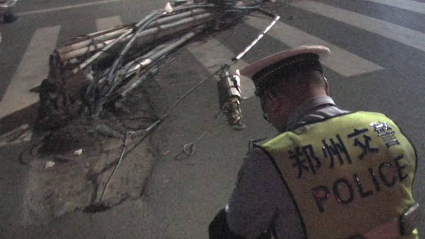 郑州闹市区两根线杆“连根拔起”，几十根线缆垂落地面阻通行