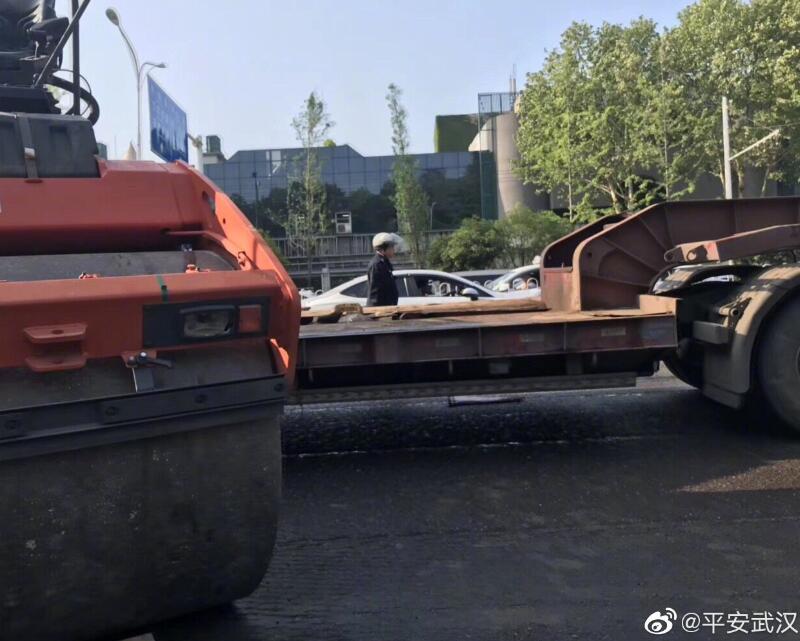 早上轧路机掉下平板运输车,致武珞路交通不畅,刚刚轧路机已被吊起