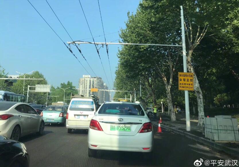 早上轧路机掉下平板运输车,致武珞路交通不畅,刚刚轧路机已被吊起