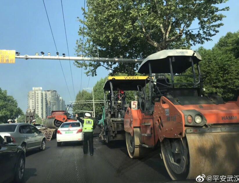 早上轧路机掉下平板运输车,致武珞路交通不畅,刚刚轧路机已被吊起