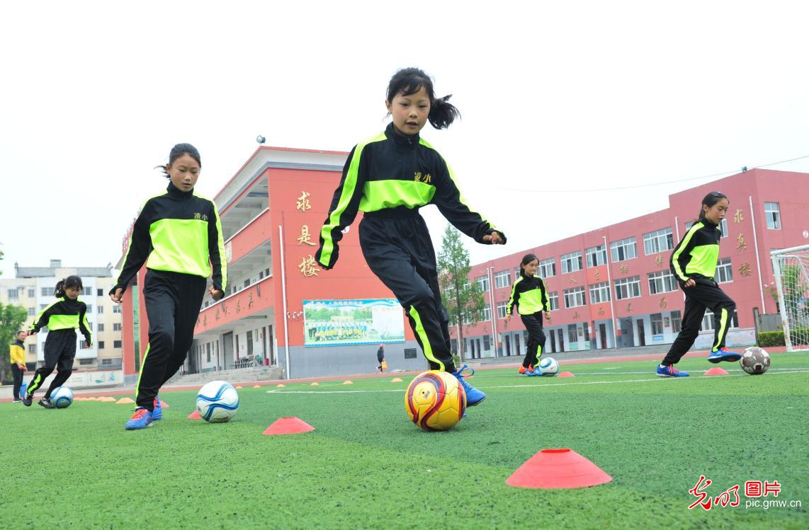 汗洒绿茵追逐足球梦的女童