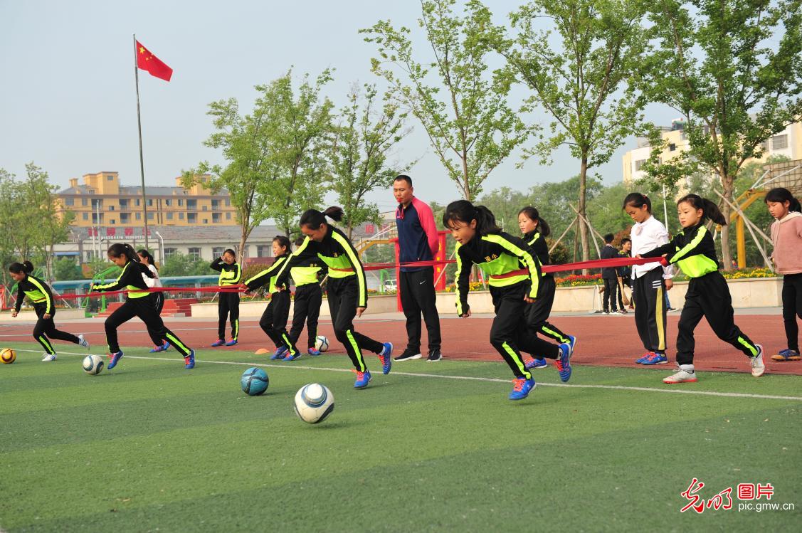 汗洒绿茵追逐足球梦的女童