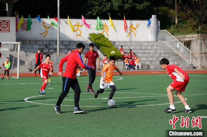 将“足球梦想”种进校园重庆斯威队球员与小学生“较量”球技