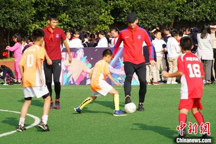 将“足球梦想”种进校园重庆斯威队球员与小学生“较量”球技