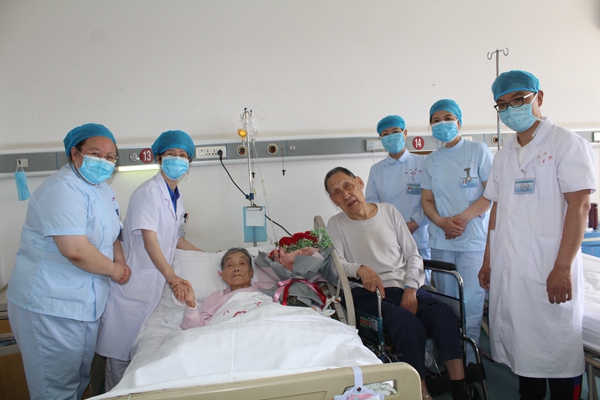 92岁老人坐轮椅在病房为89岁妻子送鲜花庆祝结婚65周年