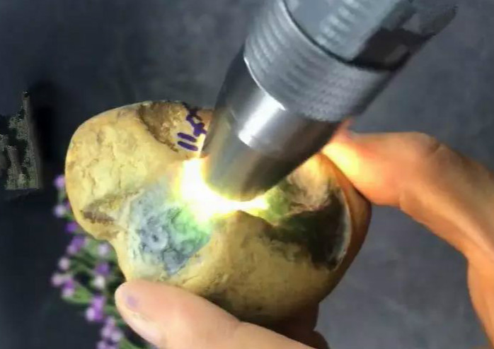 缅甸矿区翡翠原石一刀切出千万元,翡翠原石一刀切开