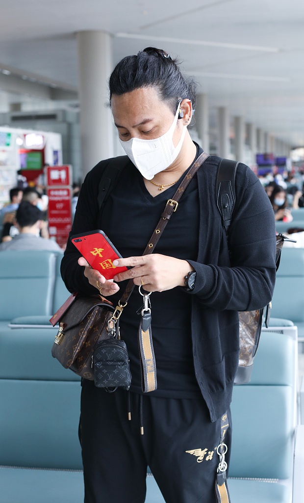 陈志朋回归低调？背3个LV包走机场，走哪都带着五星爱国手机壳