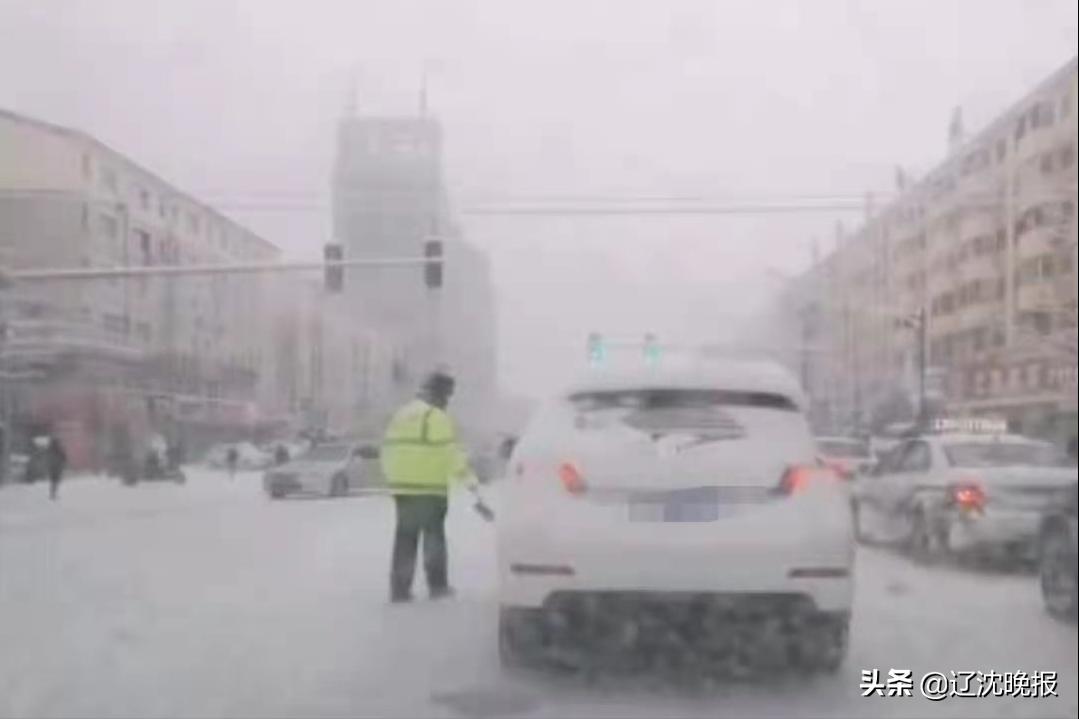 交警为等红灯车辆扫积雪,沈阳交警帮等红灯的车辆清扫积雪