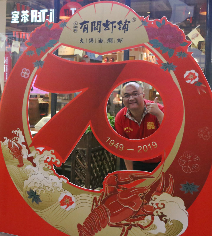 这家虾铺有搞作，在红色的海洋中剥龙虾看球，好热闹